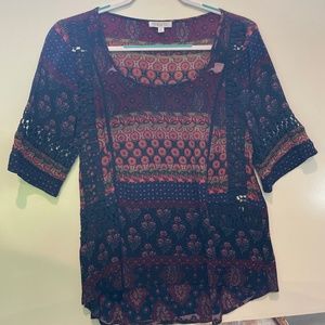 Floral top with crochet design on sleeves and front.